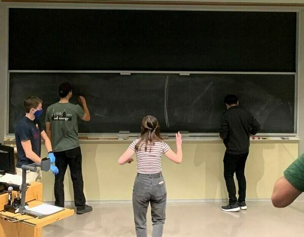 Club members play pictionary during general meeting